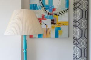 a lamp with a white lamp shade next to a painting at Apartment Zeus in Calpe