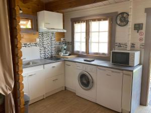 eine Küche mit einer Waschmaschine und einer Mikrowelle in der Unterkunft Chalet in Le Teich