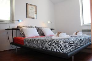 ein Schlafzimmer mit einem Bett mit zwei ausgestopften Tieren darauf in der Unterkunft Apartments PineWood Villa in Krk
