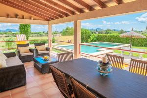 un patio con mesa y sillas y una piscina en Can Jaume, en Pollensa