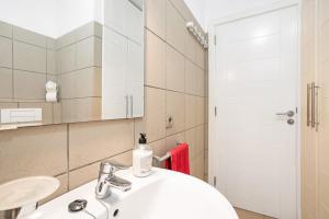 Un baño con un lavabo blanco y un espejo. en Casa Médano 3 By Médano Rentals, en El Médano 17 fotos más