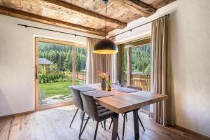 comedor con mesa de madera y ventana grande en Chalet zu Wosser, en San Leonardo in Passiria