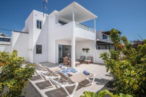 a white house with a patio and chairs at Alegria in Puerto del Carmen