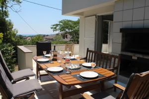 a wooden table and chairs on a patio at Apartments PineWood Villa in Krk