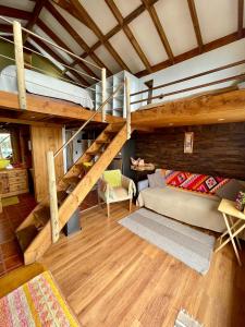 sala de estar con cama elevada y sofá en Cabañas Fischer SpA, en Niebla