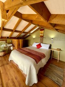 Cabañas Fischer SpA في نيبلا: غرفة نوم بسرير كبير في غرفة بسقوف خشبية