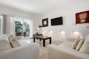 a living room with two white couches and a tv at Villa 87 in Corralejo