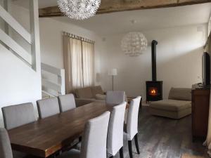 a dining room with a table and chairs and a fireplace at Gite de charme à Frémainville dans le vexin in Frémainville