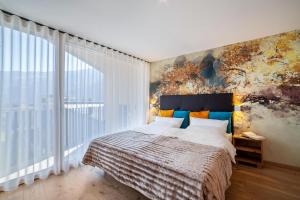 ナトゥルノにあるAdler Living Attika Wohnungの大きなベッドと大きな窓のある寝室