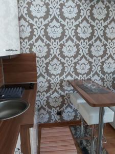 uma casa de banho com um lavatório, uma mesa e uma parede em MR. O Apartments Kopaonik em Kopaonik