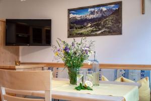 una mesa de comedor con un jarrón de flores. en Bergblick App Fichte, en Villnoss