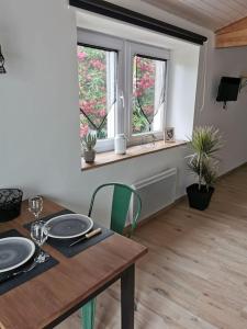 a dining room with a table and two windows at Chaleureux Studio de 35m2 totalement indépendant in Fors