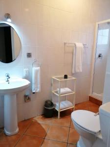 La salle de bains est pourvue d'un lavabo, de toilettes et d'un miroir. dans l'établissement Cape Town Beachfront Apartments at Leisure Bay, au Cap