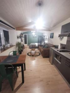 eine Küche und ein Wohnzimmer mit einem Tisch und einem Sofa in der Unterkunft Chaleureux Studio de 35m2 totalement indépendant in Fors