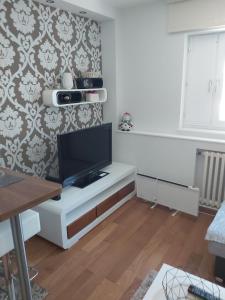 uma sala de estar com uma televisão num armário branco em MR. O Apartments Kopaonik em Kopaonik