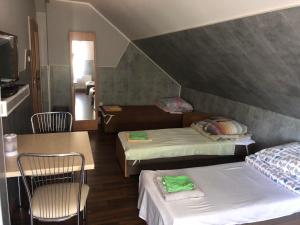 um quarto com duas camas e uma mesa e cadeiras em Zajazd Pod Swierkiem em Grajewo