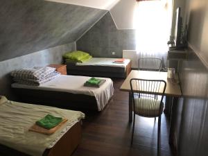a room with three beds and a table and chairs at Zajazd Pod Swierkiem in Grajewo