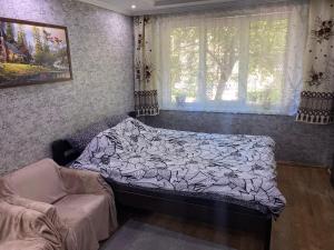 a bed in a room with a window and a couch at Квартира на Проспекті in Uzhhorod