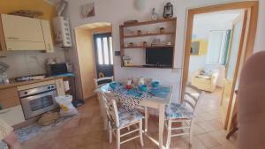 une cuisine avec une table et des chaises dans une pièce dans l'établissement La casetta dei pesciolini, à Sestri Levante 46 autres photos