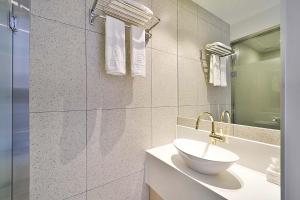 Baño blanco con lavabo y espejo en Browndot Signature Hotel en Yongjae