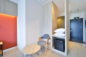 Mały pokój ze stołem, krzesłem i łóżkiem w obiekcie Browndot Signature Hotel w mieście Yongjae