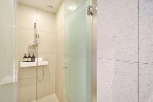 La salle de bains est pourvue d'une douche avec une porte en verre. dans l'établissement Browndot Signature Hotel, à Yongjae