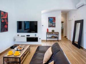 ein Wohnzimmer mit einem Sofa und einem TV in der Unterkunft Villa Confort in Denia