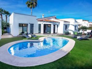 een huis met een zwembad in de tuin bij Villa Confort in Denia