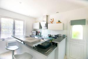 eine weiße Küche mit einer Theke und einem Fenster in der Unterkunft Sable et Reflets - T2 - Centre ville d'Hossegor in Soorts-Hossegor