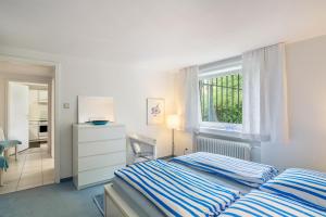 a bedroom with a bed and a dresser and a window at Ferienwohnung Götz in Bad Liebenzell