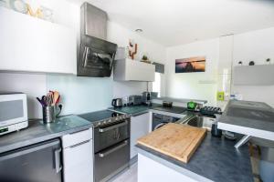 eine Küche mit Geräten aus Edelstahl und einem Schneidebrett aus Holz in der Unterkunft Sable et Reflets - T2 - Centre ville d'Hossegor in Soorts-Hossegor