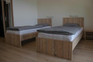 two twin beds in a room with wooden floors at BB Gore in Dol pri Hrastniku