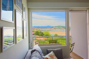 uma sala de estar com uma grande janela com vista em Apartamento Vista Picos em San Vicente de la Barquera