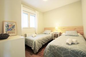 um quarto com 2 camas e uma janela em Apartamento Vista Picos em San Vicente de la Barquera