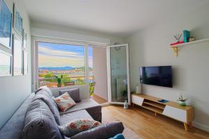 uma sala de estar com um sofá e uma grande janela em Apartamento Vista Picos em San Vicente de la Barquera