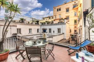 Un patio con una mesa y sillas en un balcón. en San Teodoro Apartment with Private Terrace, en Nápoles
