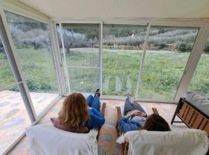 zwei Mädchen, die auf dem Boden liegen und aus dem Fenster schauen in der Unterkunft Paraíso Cuántico in Eslida