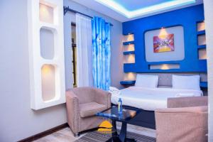 um quarto com uma cama, uma cadeira e uma mesa em Galaxy Resort Kitengela em Athi River