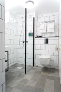 a bathroom with a shower and a sink and a toilet at Clarion Collection Hotel Tollboden in Drammen