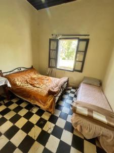 pokój z 2 łóżkami i podłogą wyłożoną szachownicą w obiekcie HOTEL DU PARC w Fezie