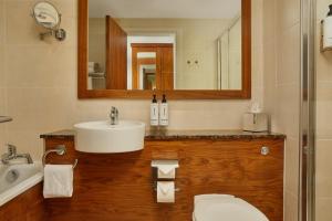 a bathroom with a sink and a toilet and a mirror at The Gateway Hotel in Dundalk