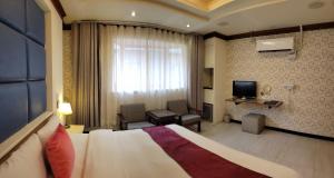 a hotel room with a bed and a television at Alia Motel in Sanxia