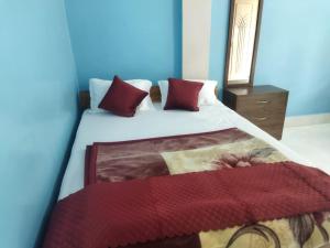 a bedroom with a bed with red pillows at Hotel Nambrog in Bomdila