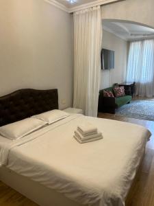 1 dormitorio con 1 cama con 3 toallas en Guest house Medea, en Kutaisi