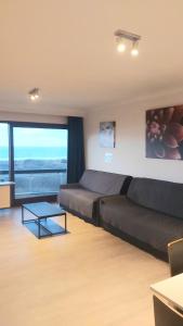Cette chambre comprend un lit, un canapé et une table. dans l'établissement Studio met zeezicht, à Blankenberge