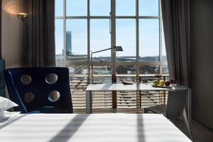a hotel room with a bed and a desk and a window at DoubleTree by Hilton Turin Lingotto in Turin