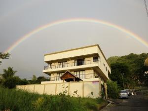 a rainbow over a building with at Happy Days Guest House in Le Morne