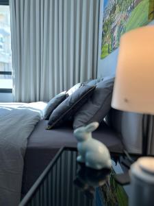 1 dormitorio con 1 cama con almohadas y lámpara en White Door Apartments en Haifa