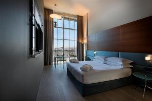a hotel room with a bed and a large window at DoubleTree by Hilton Turin Lingotto in Turin