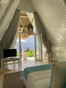 a bedroom with a bed and a view of the ocean at Piramida's White Villa's Bali in Canggu